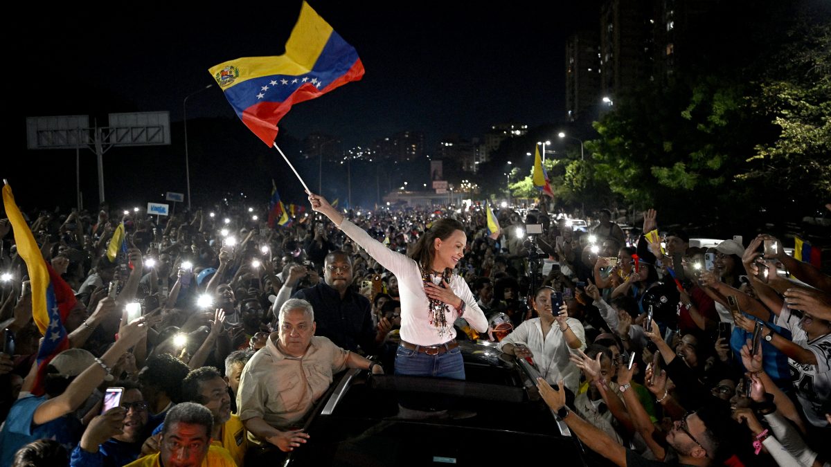 La líder opositora venezolana y galardonada con el Premio Nobel de la Paz, María Corina Machado, ondea una bandera de Venezuela mientras saluda a sus seguidores a su llegada a Caracas el 25 de octubre de 2026. Machado regresó a su país natal el 25 de octubre de 2026, tras casi un año en el exilio, y fue recibida por seguidores eufóricos en una iglesia de la ciudad de Barquisimeto. (Foto de Federico PARRA / AFP)