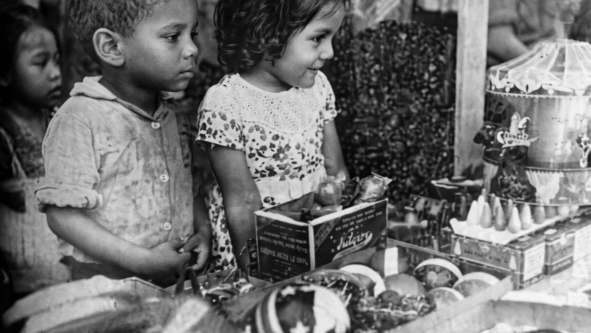 Niños observan el escaparate de una juguetería en Managua durante la Navidad de 1950. Tras publicar la fotografía, LA PRENSA les envió los juguetes que contemplaban. LA PRENSA / IMAGEN RESTAURADA CON IA