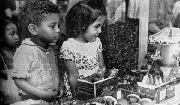 Niños observan el escaparate de una juguetería en Managua durante la Navidad de 1950. Tras publicar la fotografía, LA PRENSA les envió los juguetes que contemplaban. LA PRENSA / IMAGEN RESTAURADA CON IA
