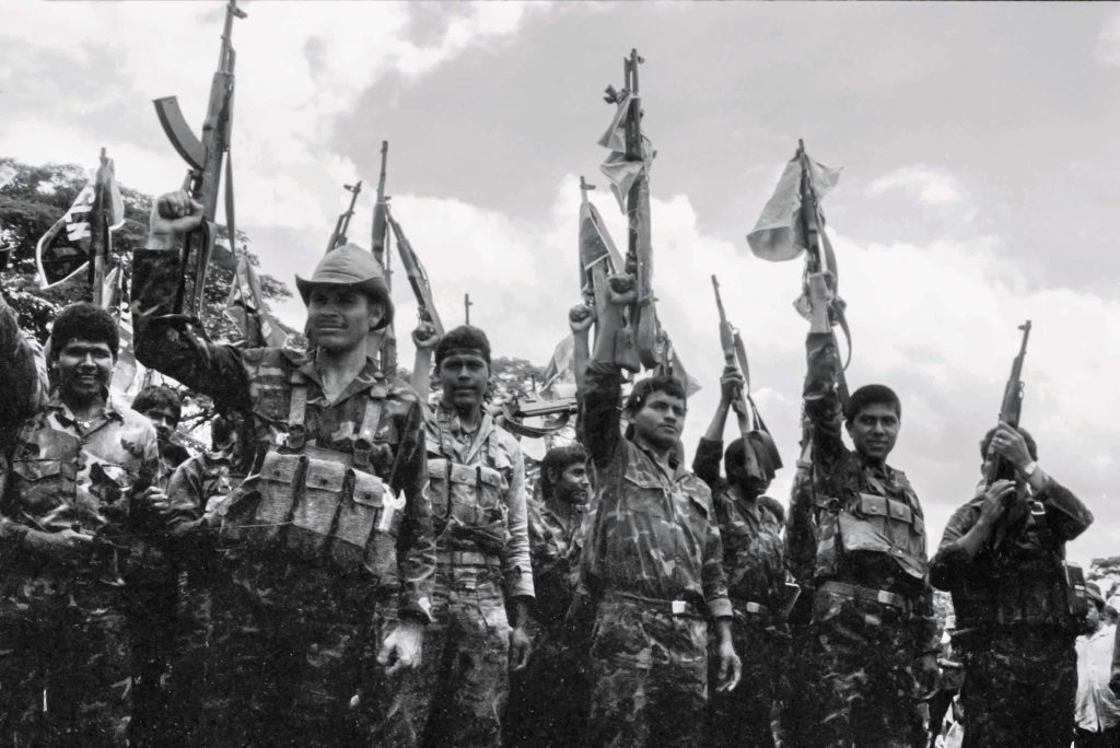 Soldados del Servicio Militar Obligatorio alzan sus fusiles AK-47 durante una actividad partidaria en Pantasma a finales de la década de 1980. LA PRENSA / ARCHIVO PERSONAL ÓSCAR NAVARRETE
