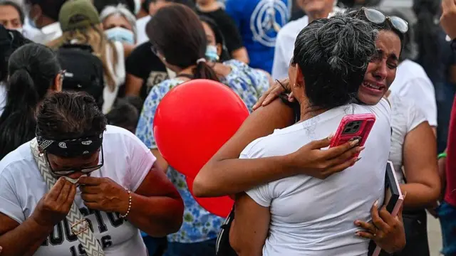 Personas en La Guaira, en Venezuela, se abrazan tras una misa por las víctimas de los sismos de junio